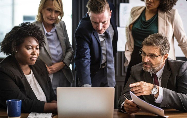 Team reviewing a laptop and documents during a meeting